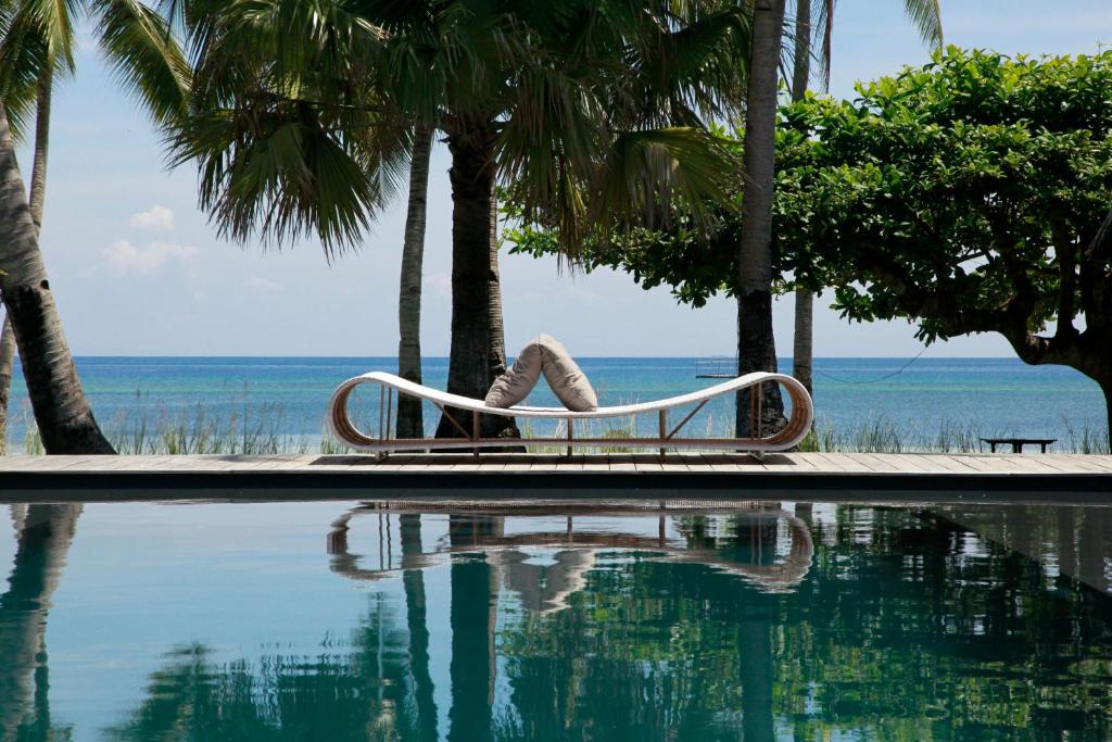 eine Person, die auf einem Stuhl neben einem Pool sitzt in der Unterkunft Ananyana Leisure Beach Resort in Panglao