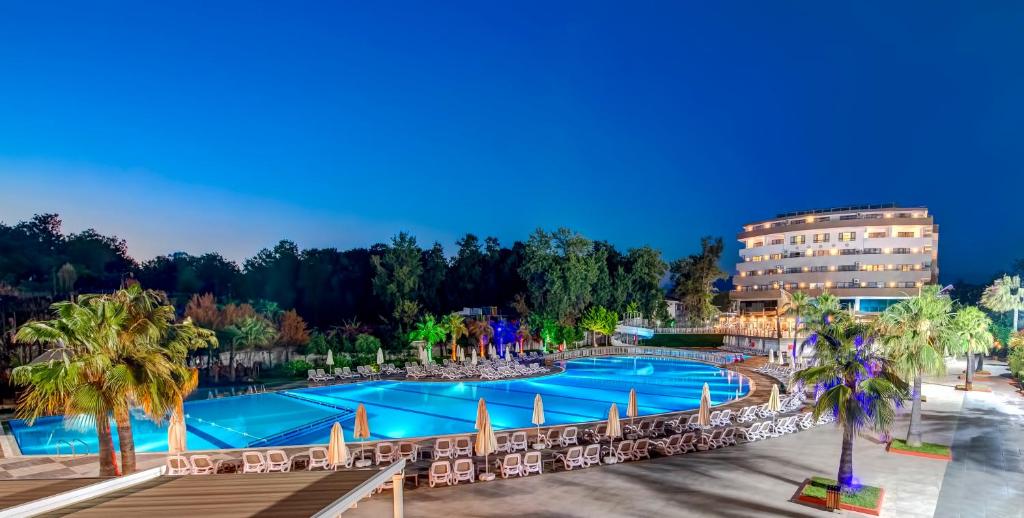 una vista aérea de una piscina del complejo con sillas y palmeras en Bera Alanya Hotel - Halal All Inclusive en Konaklı