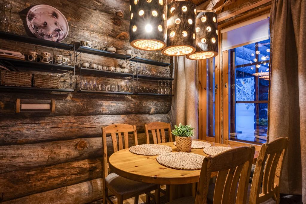 ein Esszimmer mit einem Holztisch und Stühlen in der Unterkunft Kuusirinne 2B -A cozy cabin near the slopes of Ruka in Ruka