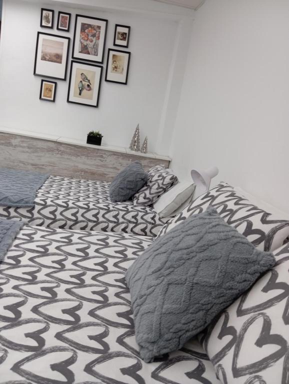 1 Schlafzimmer mit 2 Betten mit Kissen und Bildern an der Wand in der Unterkunft apartamento genil in Granada