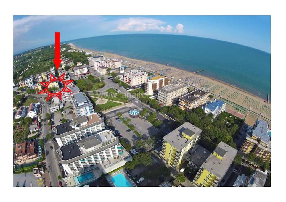 uma seta vermelha no topo de um edifício perto da praia em allinclusive em Lido di Jesolo