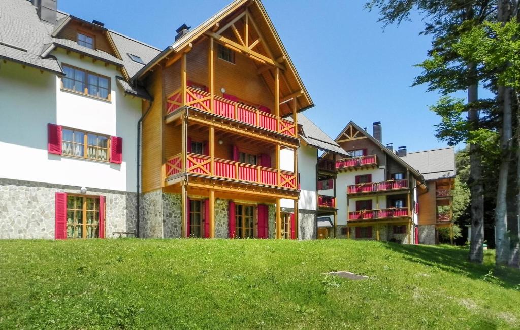 a large building with red balconies and a yard at Awesome Apartment In Pohorje With Indoor Swimming Pool in Hočko Pohorje
