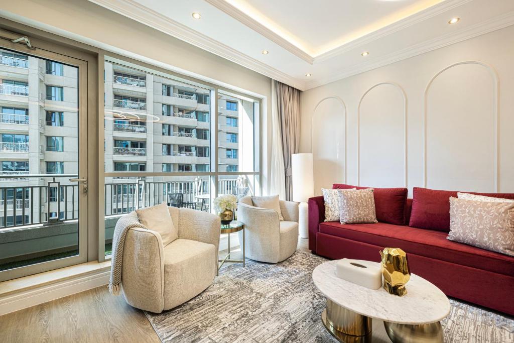 een woonkamer met een rode bank en stoelen bij Magnificent Cozy 2 BR in Downtown Dubai in Dubai