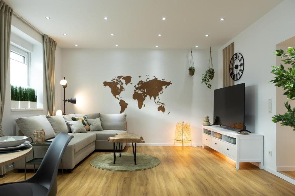 uma sala de estar com um sofá e um mapa do mundo na parede em Ferienwohnung mit Terrasse - Erdgeschoss em Weilburg