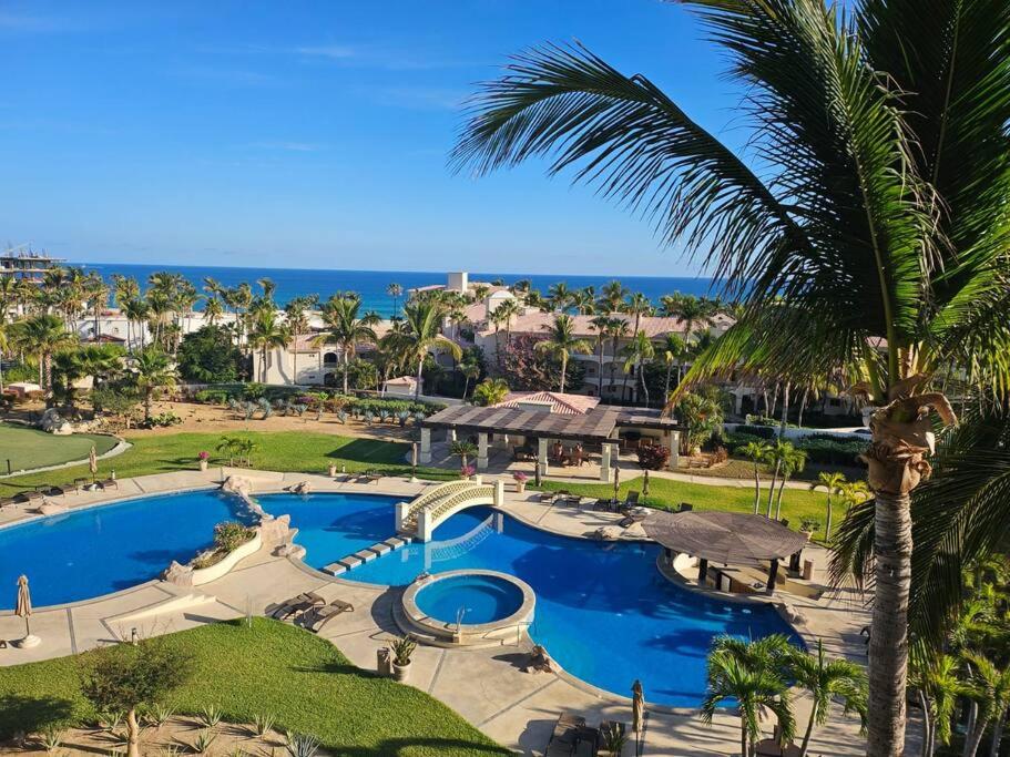 an aerial view of a resort pool with a palm tree at Entire Beachfront condo in Paradise in San José del Cabo