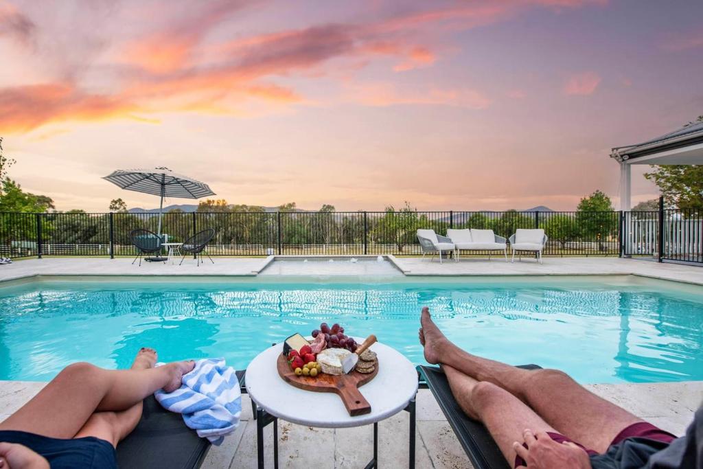 dos personas en el borde de una piscina en 'Bonnie View' A Magnificently Luxurious Retreat, en Mudgee