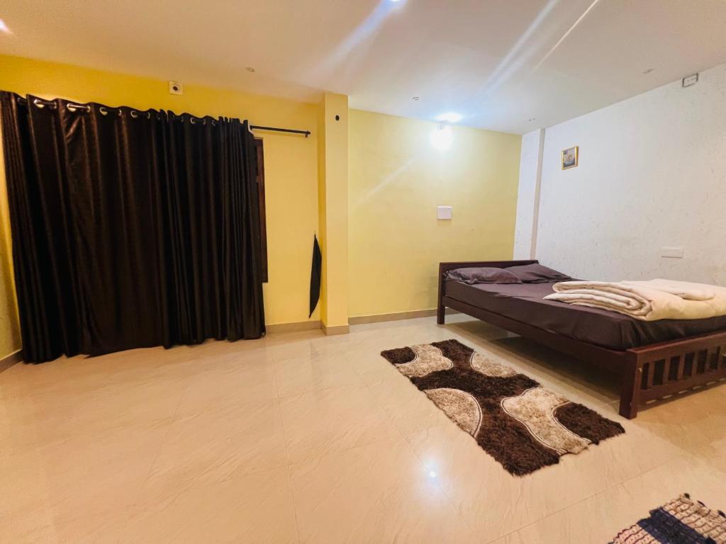 a bedroom with a bed and a black curtain at Leisure familyvillas in Padinjarathara
