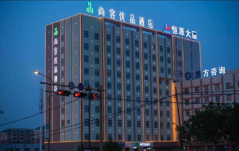 un edificio con un semáforo delante de él en Thank Inn Chain Hotel Alar Impression Lanbo Bay Ecological Tourist Park, en Nanfang