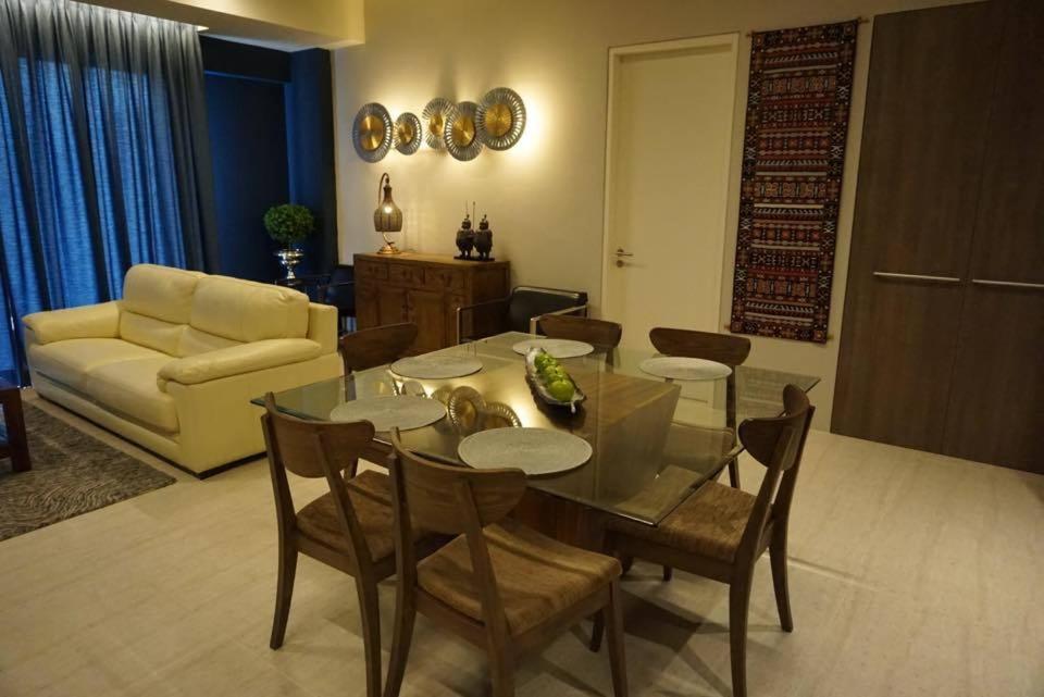 a living room with a table and chairs and a couch at Ferringhi Luxury Suite @ By The Sea in Batu Ferringhi