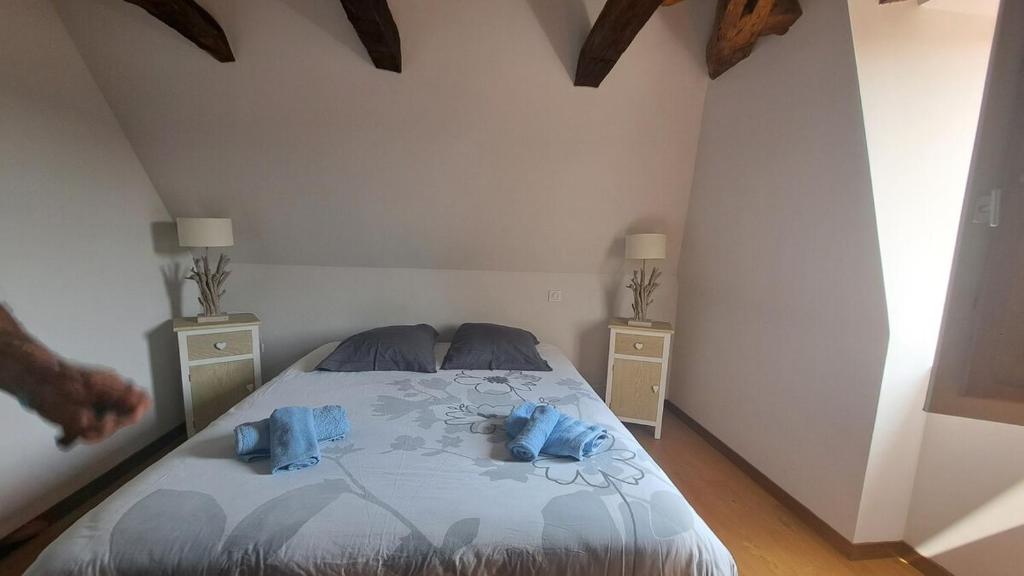 a bedroom with a bed with blue towels on it at Le Coeur de Domme in Domme