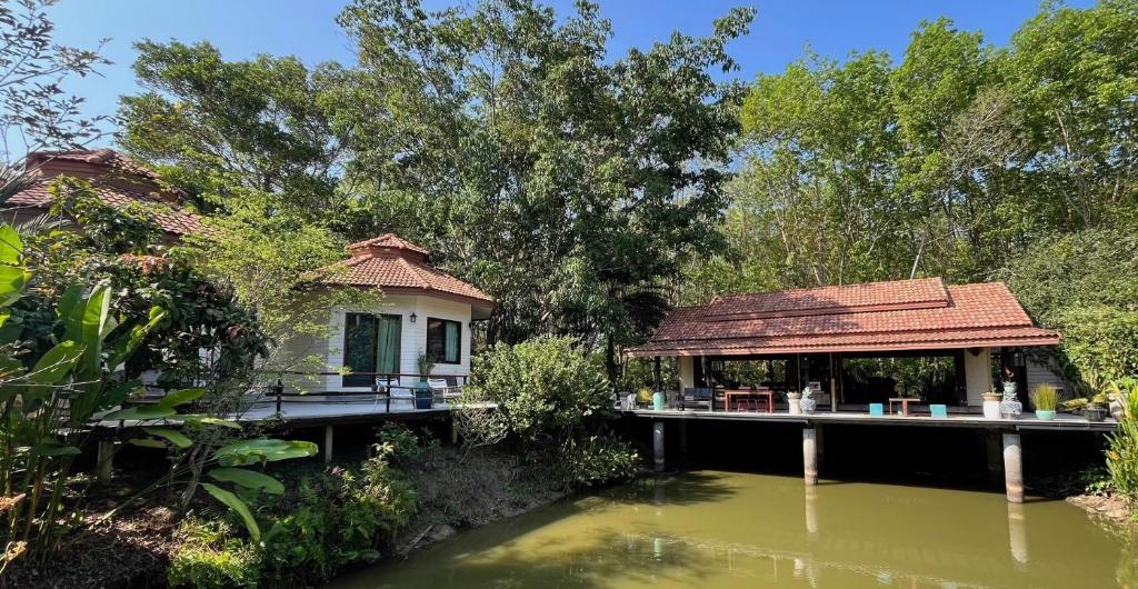 a house on a dock next to a body of water at Navari Homestay in Rayong