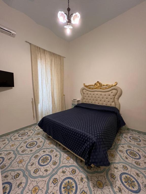1 dormitorio con 1 cama con edredón azul en beb Rosy, en Nápoles