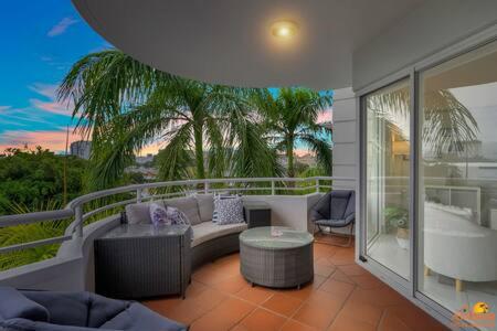 uma sala de estar com um sofá e uma banheira numa varanda em The heart of Cairns City with panoramic views em Cairns