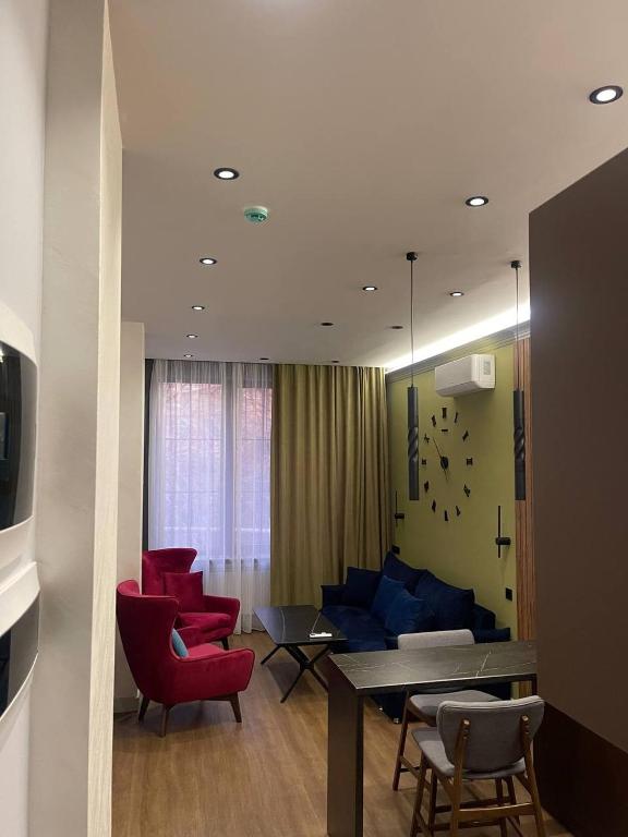 un soggiorno con un tavolo e sedie rosse di Elegant Apartment a Yerevan