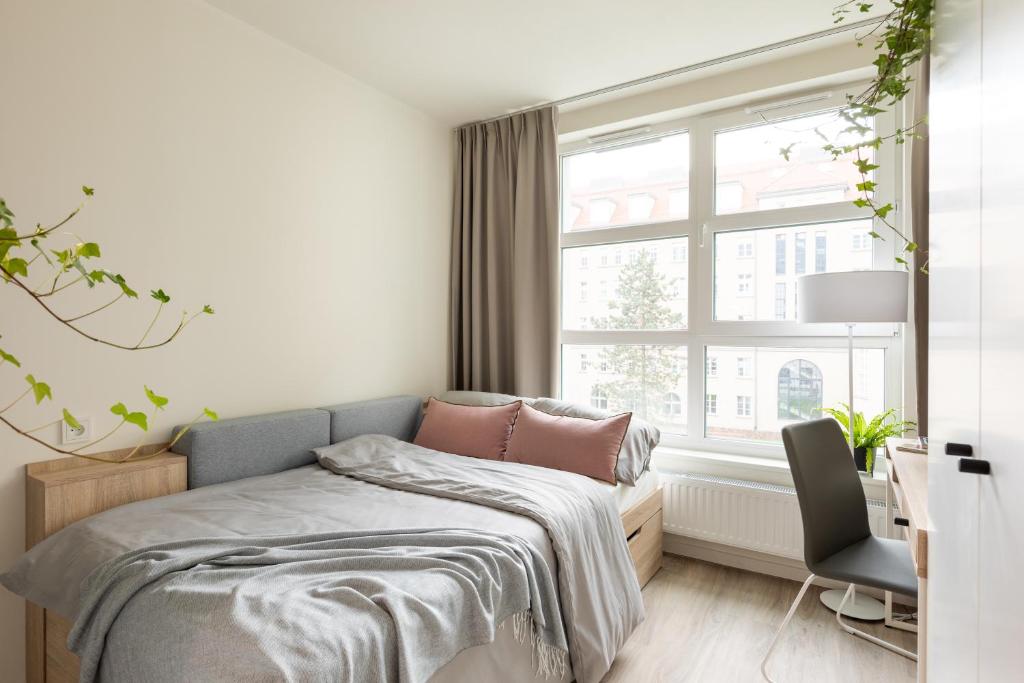 une chambre avec un lit et une fenêtre dans l'établissement MILESTONE Krakow Center Student Living, à Cracovie