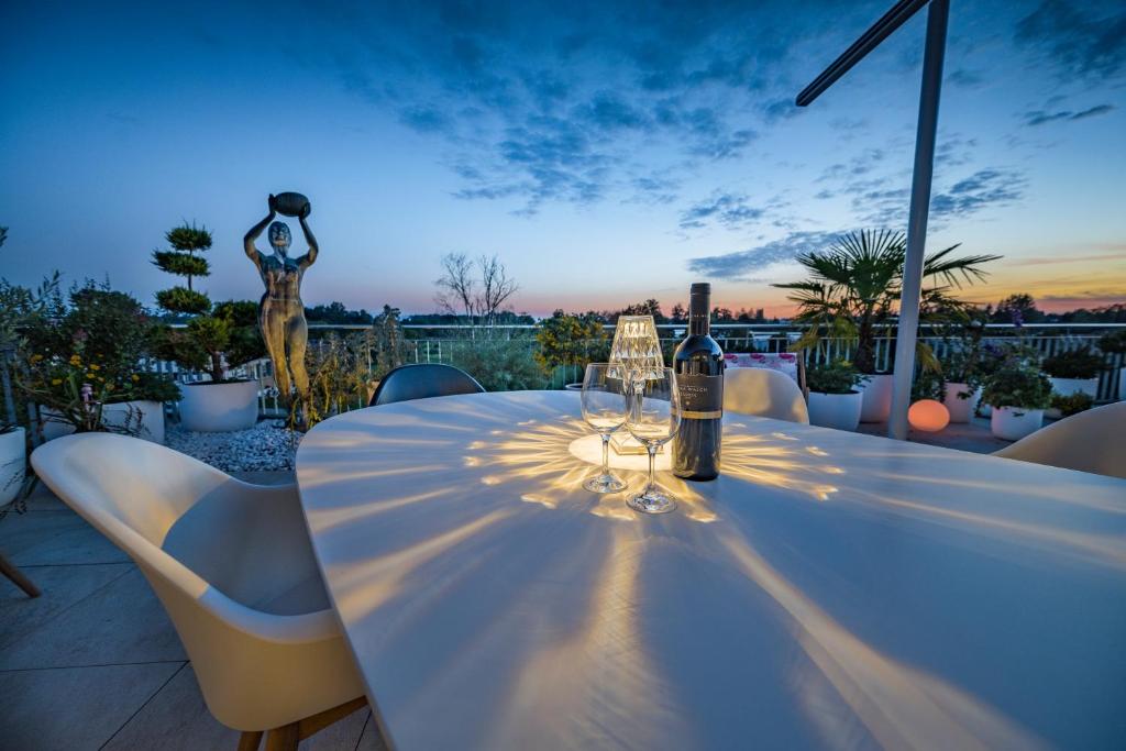 een witte tafel met wijnglazen en een standbeeld bij living TIMELESS- Design Apartment Bodensee- Friedrichshafen in Friedrichshafen