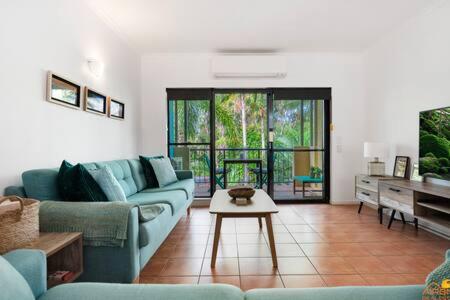 een woonkamer met blauwe banken en een tafel bij Port Douglas Vacation Holiday Unit in Port Douglas