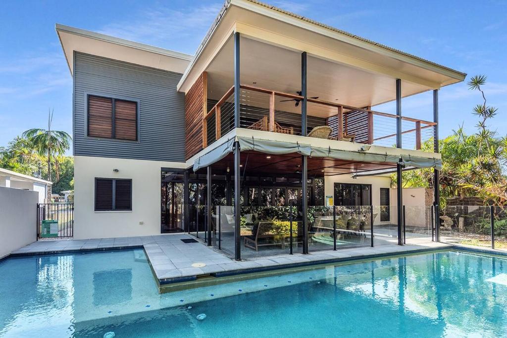 a house with a swimming pool in front of a house at Bramston Beach - Premium Holiday House in Bramston Beach