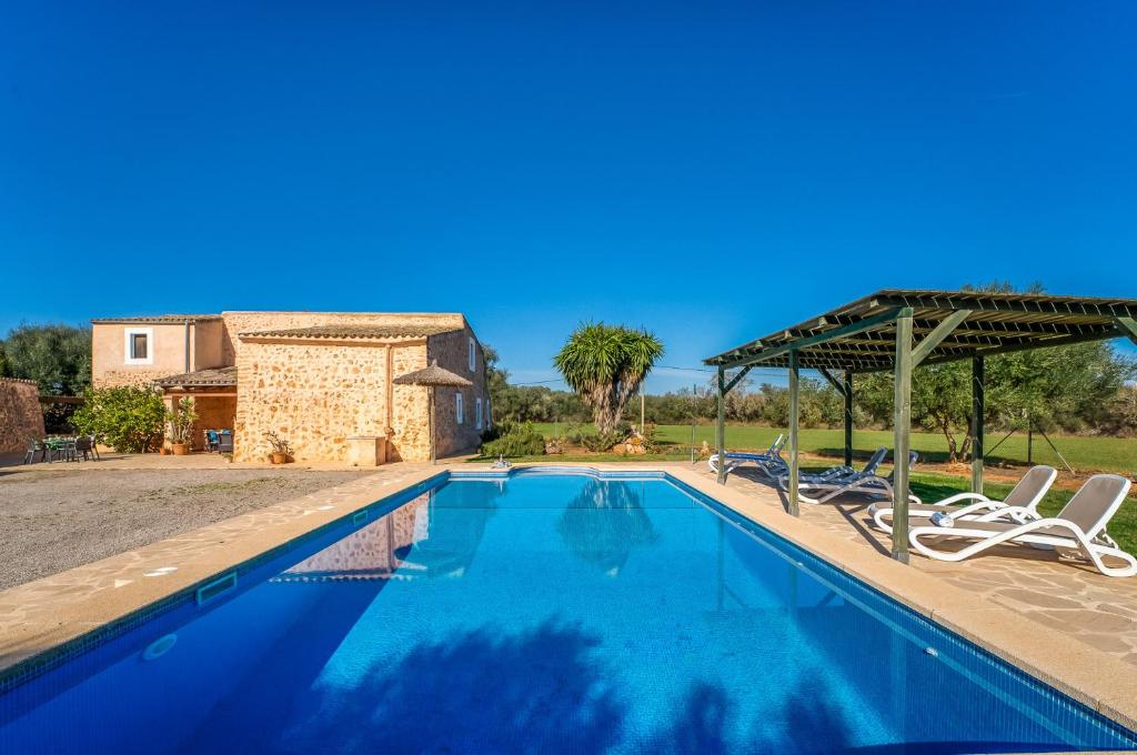 - une piscine avec 2 chaises longues et un parasol dans l'établissement Can Xim, à Felanitx