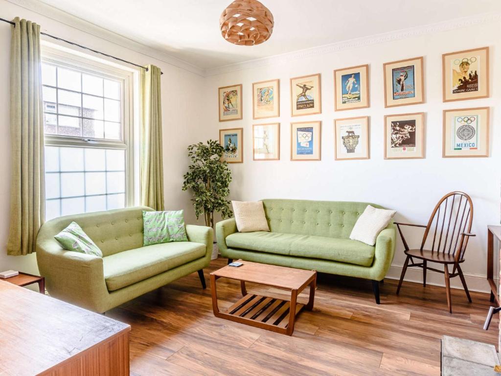 uma sala de estar com dois sofás verdes e uma mesa em 3 Bed in Shanklin 49398 em Shanklin