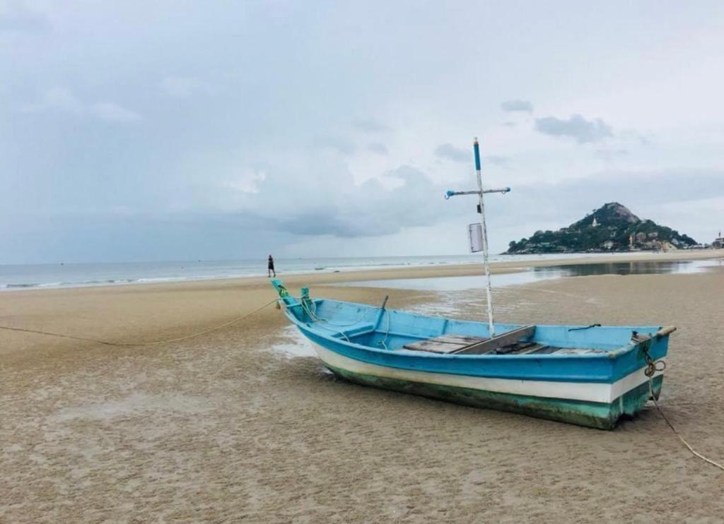 a blue boat sitting on the sand on a beach at Nicha Pool Villa in Hua Hin