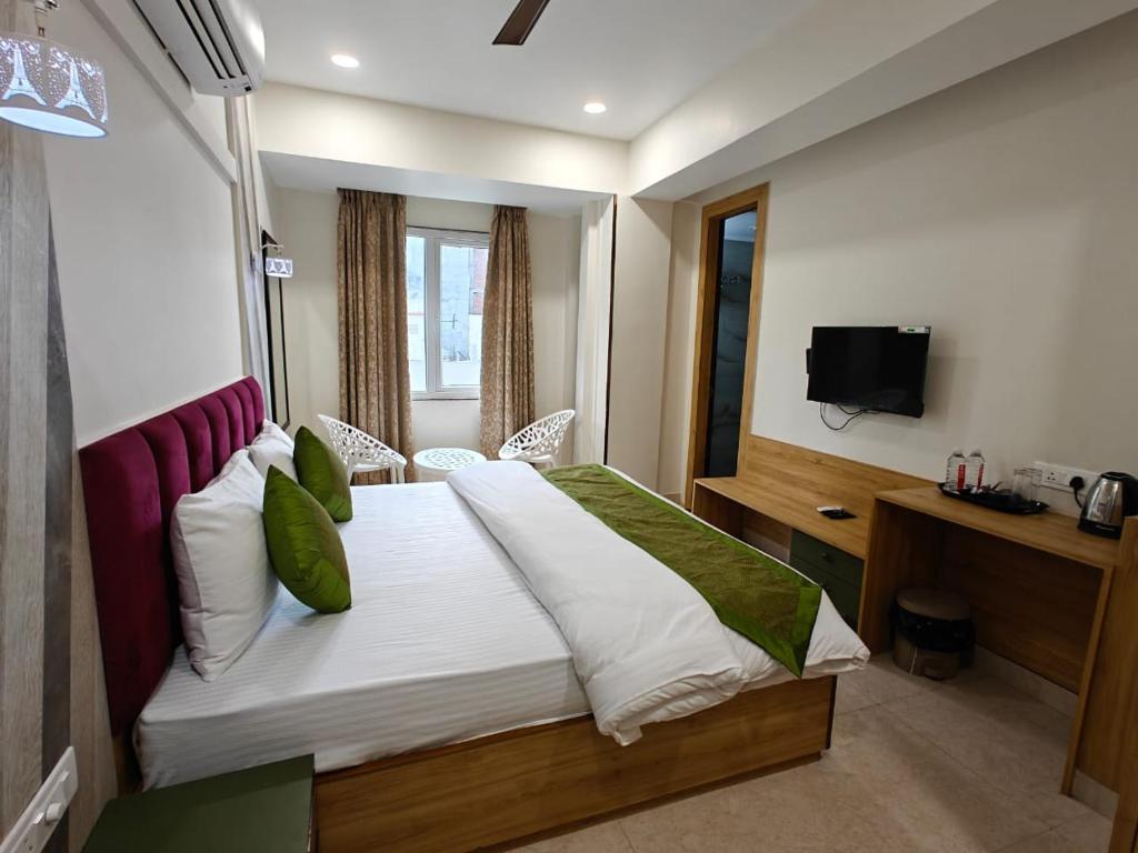 a hotel room with a bed and a television at Hotel Utsav Grand in Varanasi
