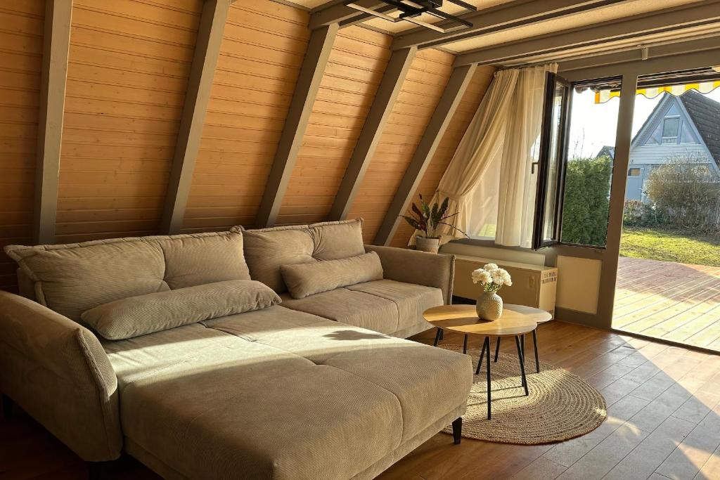 ein Wohnzimmer mit einem Sofa und einem Tisch in der Unterkunft Ferienwohnpark Immenstaad am Bodensee Nurdachhaus Typ 7 ND 56 in Immenstaad am Bodensee