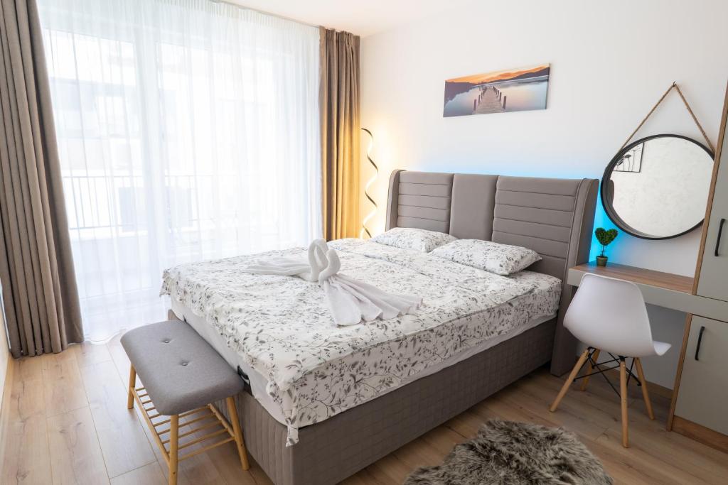 Schlafzimmer mit einem Bett, einem Spiegel und einem Fenster in der Unterkunft New Modern & Cozy apartment with free parking in Warna