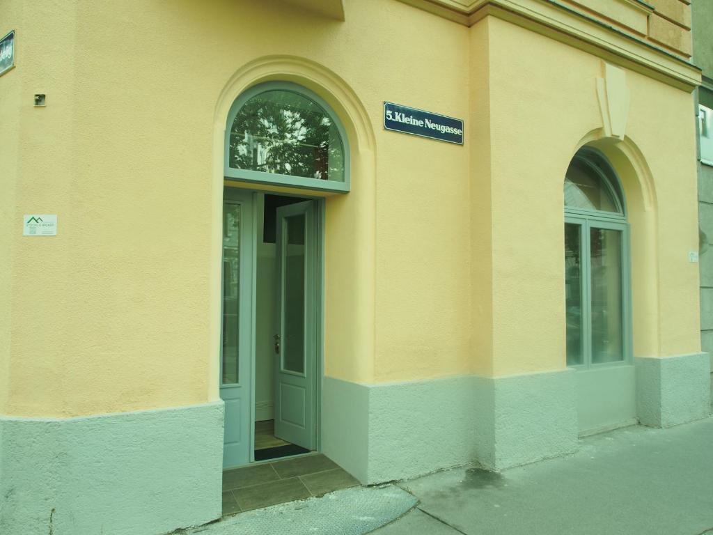un edificio amarillo con dos ventanas y una puerta en Nähe Naschmarkt en Viena