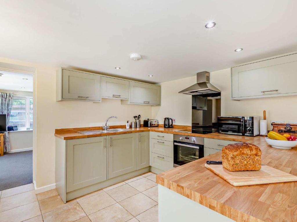 a kitchen with white cabinets and a wooden counter top at 3 Bed in Langtree 58822 in Langtree