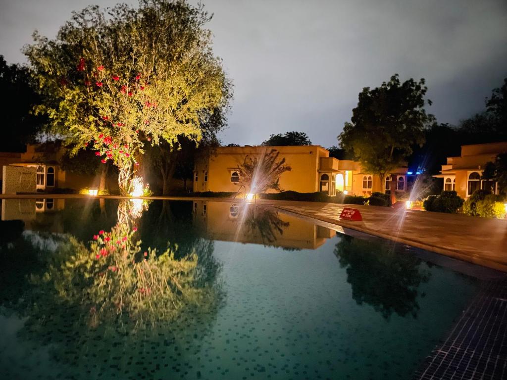 a pool of water in front of a building at night at Heritage Resort Bikaner in Bikaner