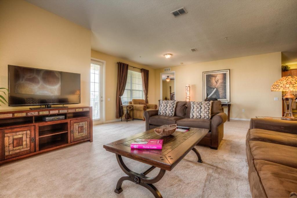 een woonkamer met een bank en een tv bij Vista Cay 44 by Top Villas in Orlando