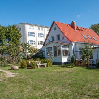 a house with a red roof in a yard at Großer Gartenbungalow Nr 3 mit Terrasse - Strandvogtei Sellin in Ostseebad Sellin
