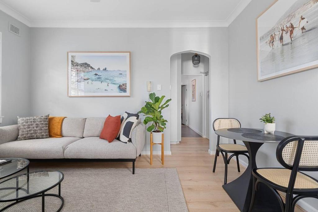 een woonkamer met een bank en een tafel bij Ocean's Embrace - A Local's Haven at Bondi Beach in Sydney