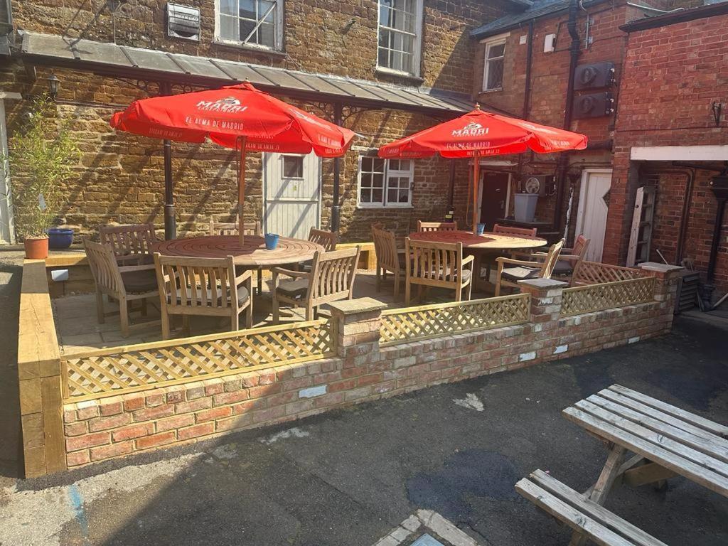 patio ze stołami, krzesłami i parasolami w obiekcie Bartholomew Arms w mieście Northampton