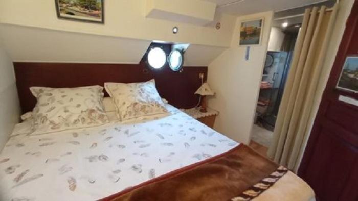 a bedroom with a bed and two lights on the wall at Bateau Mariance in Ginestas
