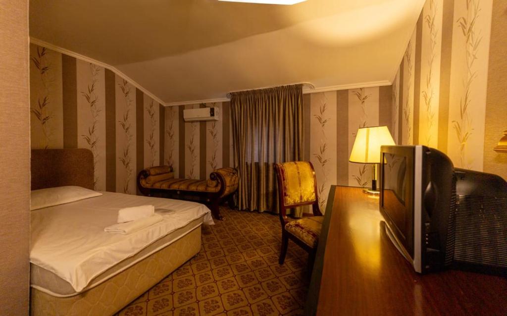 una camera d'albergo con letto e TV di Алматы Транзит №1 a Turksib