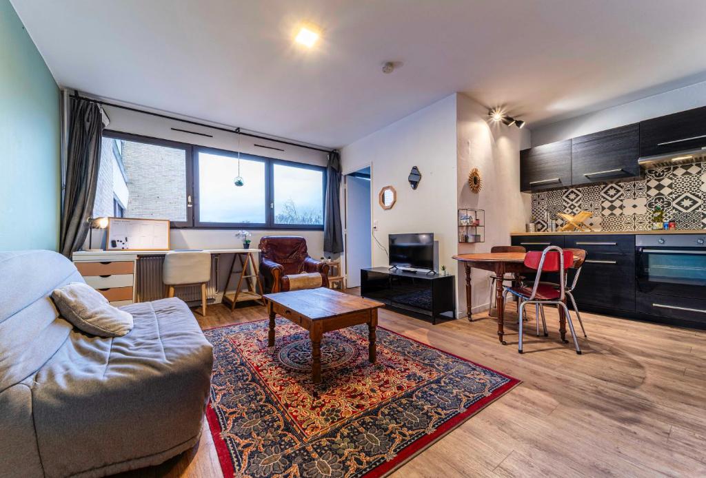 ein Wohnzimmer mit einem Sofa und einem Tisch in der Unterkunft Appartement Charmant à Lille in Lille