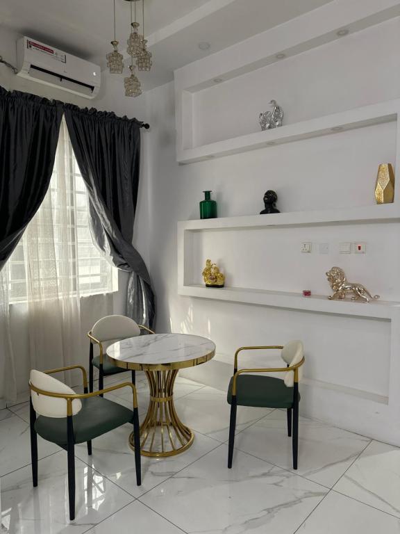een eetkamer met een tafel en stoelen en een raam bij Affordable luxury 3bed apartment in Maiyegun
