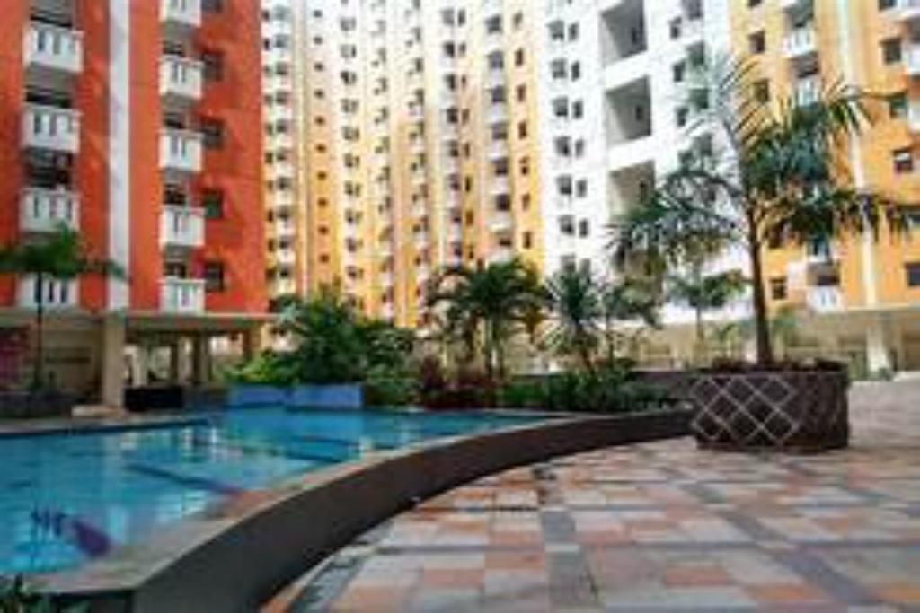 a swimming pool in a building with tall buildings at OYO 93645 Akasia Budget in Bekasi