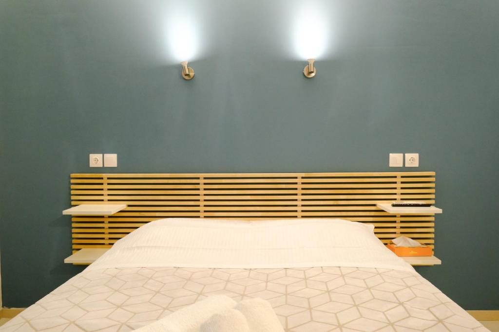 a bedroom with a bed and two lights on the wall at PARASIOU STUDIOS 102 διαμερίσματα στο κέντρο της πόλης in Komotini
