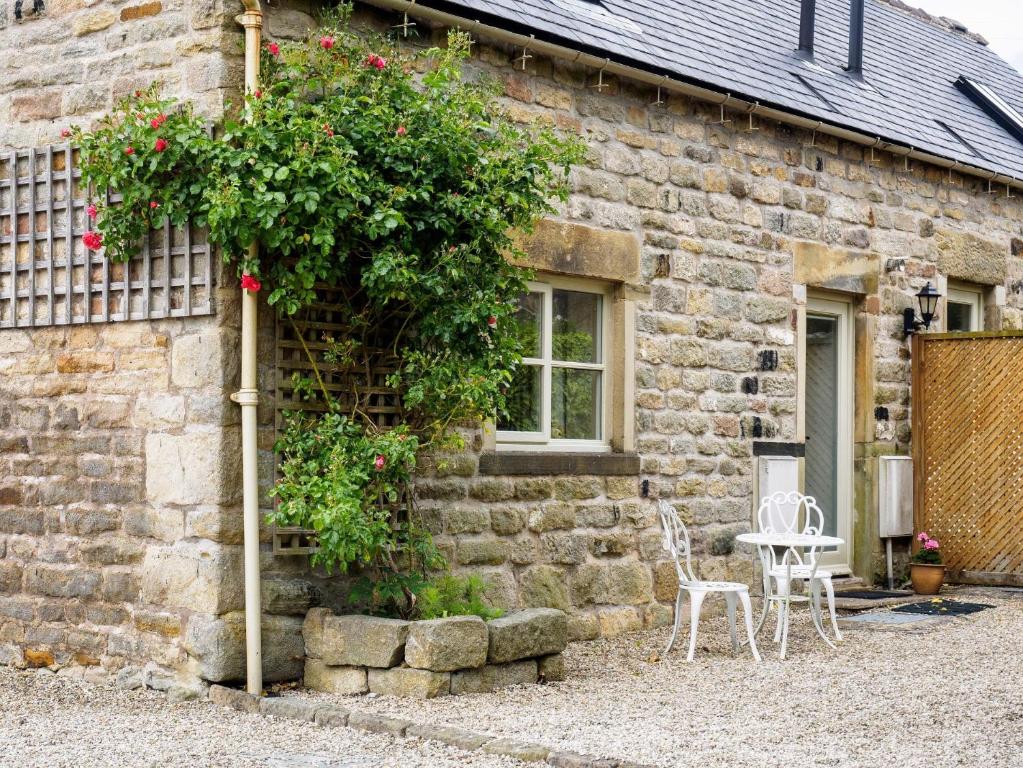 a brick building with a table and chairs in front of it at 1 Bed in Curbar PK455 in Curbar