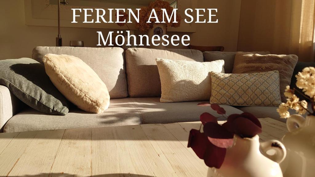 ein Wohnzimmer mit einer grauen Couch mit Kissen in der Unterkunft Ferien am See in Möhnesee