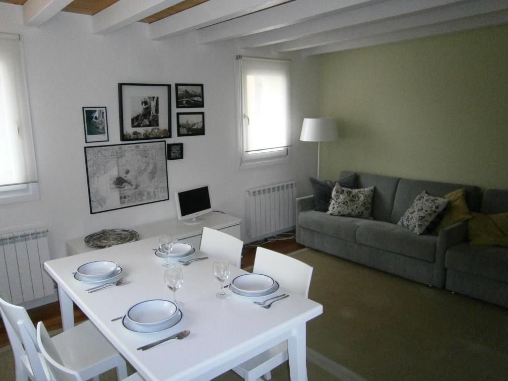 - une table et des chaises blanches dans le salon dans l'établissement Casa Incanto - Agenzia Cocal, à Caorle