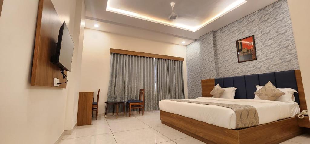 1 dormitorio con 1 cama y TV en HOTEL GRAND EKTA, en Gorwa