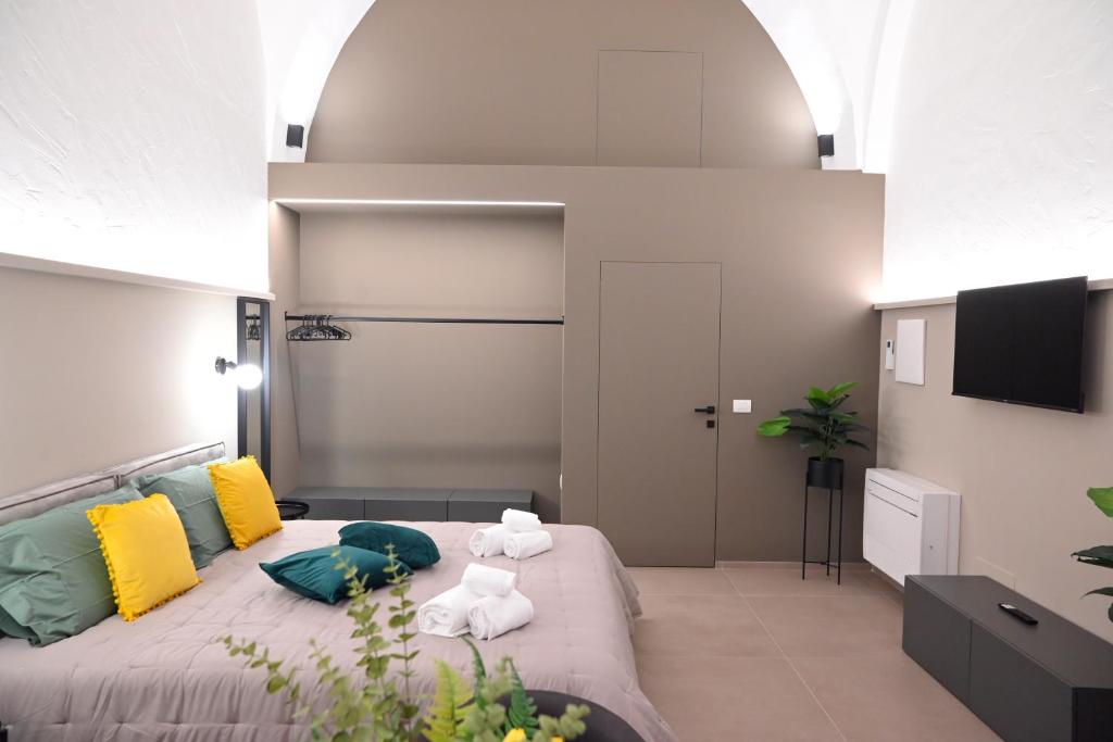 een slaapkamer met een groot bed met kleurrijke kussens bij Dimora Minelli Suites in Monopoli