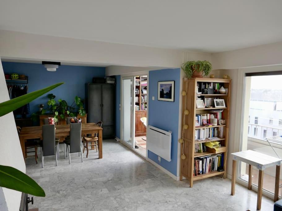 ein Esszimmer mit einem Tisch und einer blauen Wand in der Unterkunft Appart T3 Spacieux + Terrasse in Montpellier