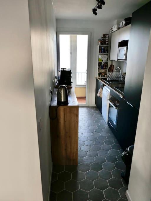 a room with a kitchen with a counter and a floor at Appart T3 Spacieux + Terrasse in Montpellier