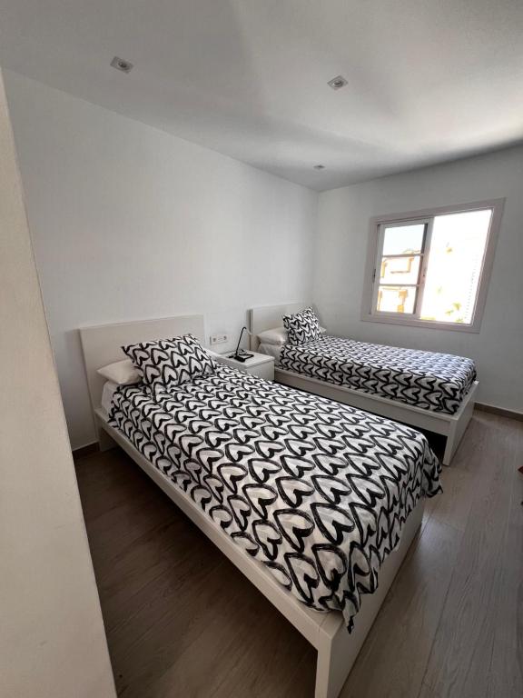 a bedroom with two beds and a window at Residence Balcòn del Atlàntico Costa Adeje in Adeje