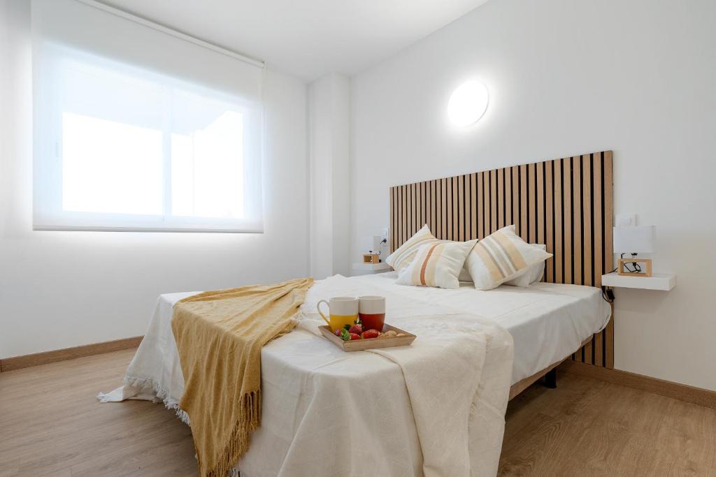 a bedroom with a bed with a tray of food on a table at Alea Rentals - Acquamarina in La Pineda